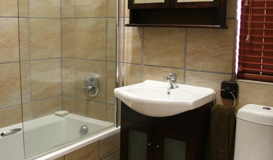 Avemore Sedgefield: This bathroom contains a basin, toilet and bath with a shower head.