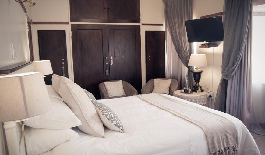 Grey Room: Grey Room - The room has a queen-size bed and a TV with selected DSTV channels, as well as an en-suite bathroom with a bath.
