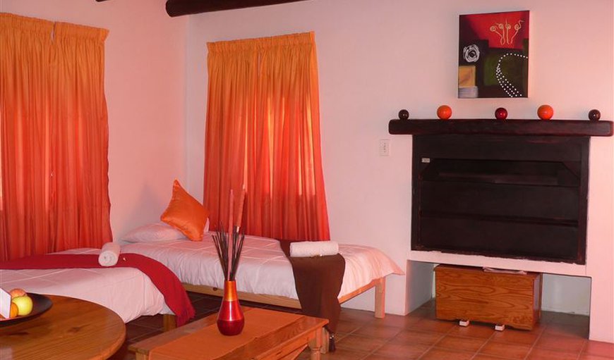 Lobster Chalet: Lobster chalet open plan lounge with twin single beds and fireplace.