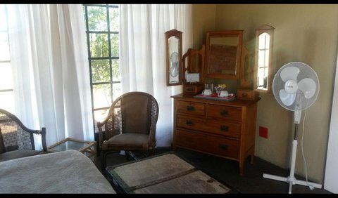 Twin Room: Twin Room with chairs, a dressing table and a fan.