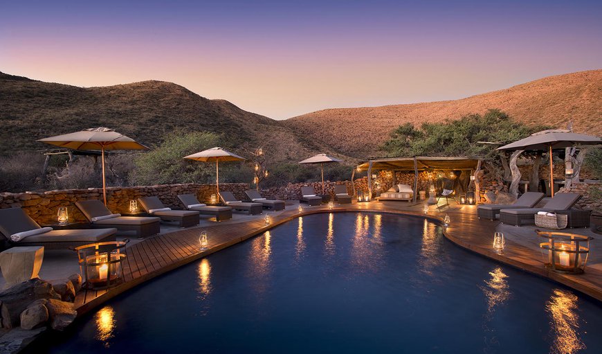 The surroundings are elegantly simple with a luxury swimming pool opening to the remarkable scene of animals drinking at a nearby watering hole. The surroundings are elegantly simple with a luxury swimming pool opening to the remarkable scene of animals drinking at a nearby watering hole.
