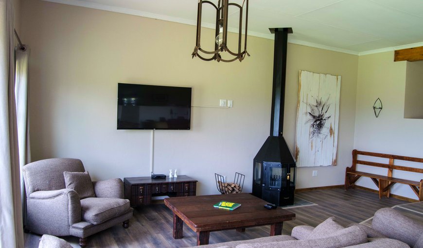 Maluti View Apartment - The lounge area is comfortably furnished with couches, a TV and a fireplace. Maluti View Apartment - The lounge area is comfortably furnished with couches, a TV and a fireplace.