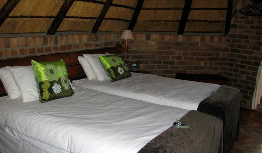 Thatched Cabins: Cabin bedroom with twin single beds.