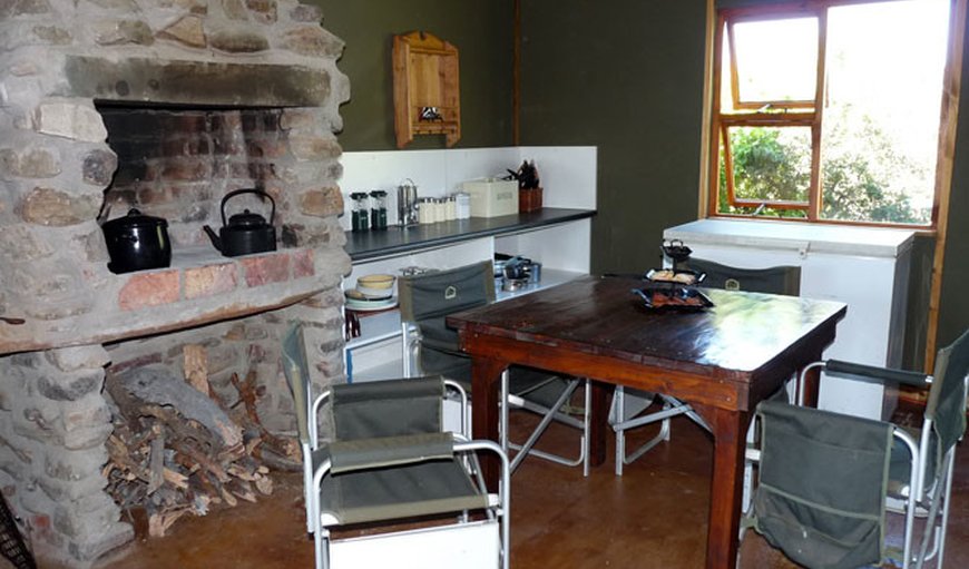 Eco-friendly, Solar-Powered Bush Cottage: Kitchen area with a fire place.