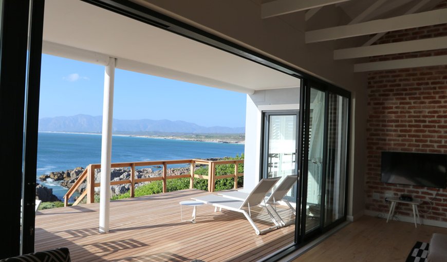 Flowing, open plan living area opening onto the wooden sea front deck