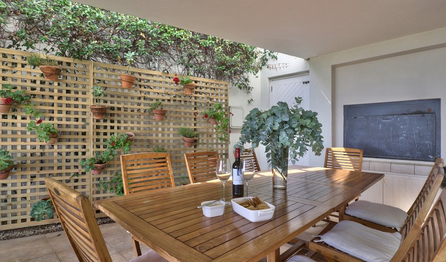 The covered patio is furnished with a built-in braai and an outdoor dining table seating eight guests. The covered patio is furnished with a built-in braai and an outdoor dining table seating eight guests.