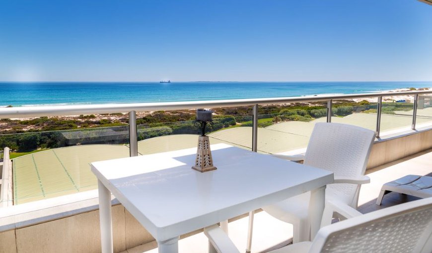 H208 Dolphin Beach features a balcony furnished with a table and two chairs.