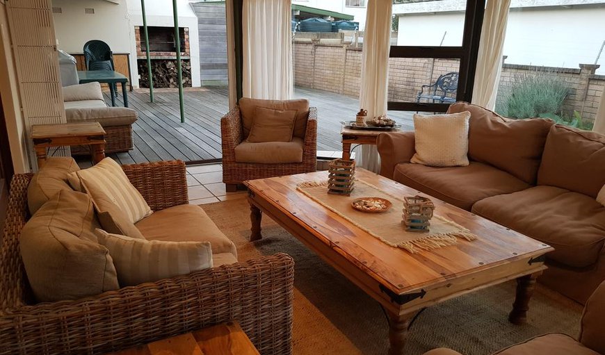 The lounge leads to a sunroom with plenty of comfortable seating. The sun room opens to a deck with outdoor dining furniture and built-in braai facilities The lounge leads to a sunroom with plenty of comfortable seating. The sun room opens to a deck with outdoor dining furniture and built-in braai facilities