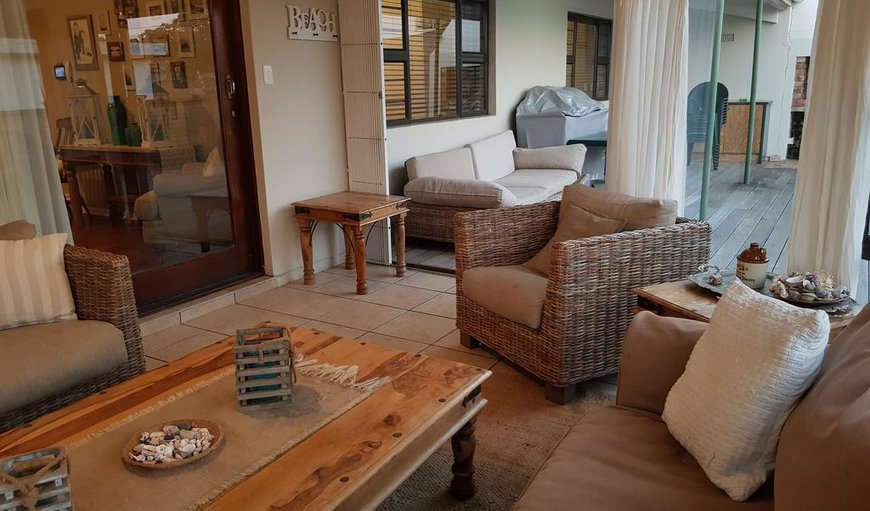 The lounge leads to a sunroom with plenty of comfortable seating. The sun room opens to a deck with outdoor dining furniture and built-in braai facilities The lounge leads to a sunroom with plenty of comfortable seating. The sun room opens to a deck with outdoor dining furniture and built-in braai facilities