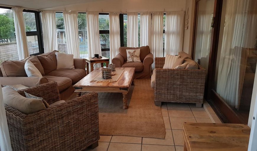 The lounge leads to a sunroom with plenty of comfortable seating. The sun room opens to a deck with outdoor dining furniture and built-in braai facilities The lounge leads to a sunroom with plenty of comfortable seating. The sun room opens to a deck with outdoor dining furniture and built-in braai facilities