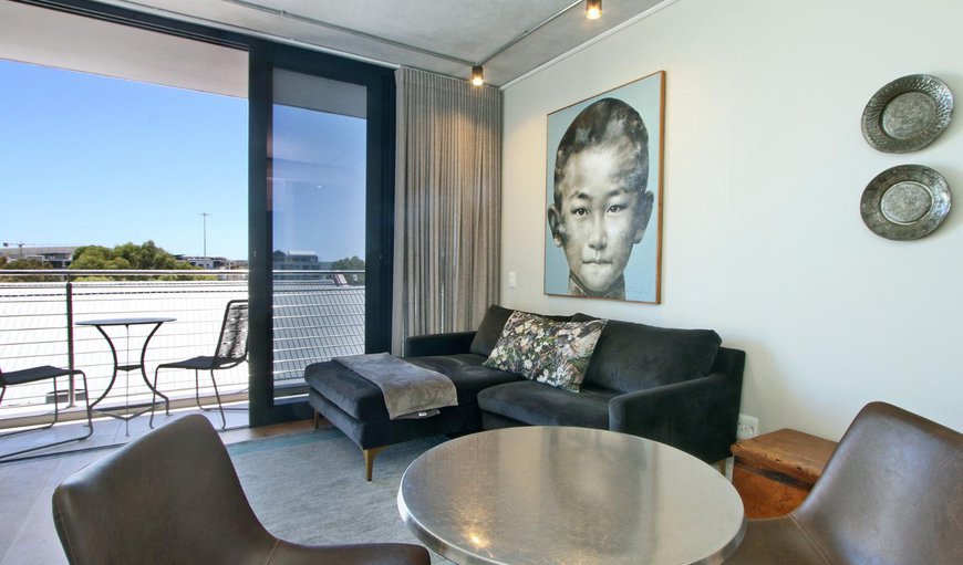 The lounge area is tastefully furnished with a comfortable couch and a TV in De Waterkant, Cape Town, Western Cape, South Africa