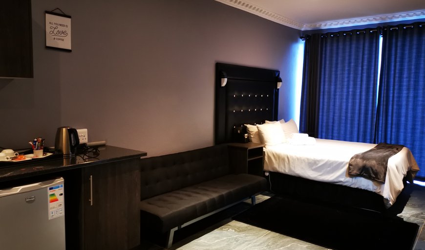 Premium Queen Room: The Premium Queen Room is a large modern room with a couch and a kitchenette