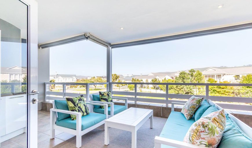 large covered patio with a built-in braai and comfy seating