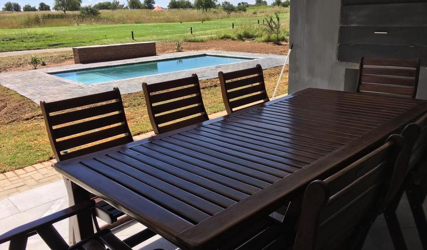 This spacious house features a patio with a braai area that leads out onto a swimming pool.