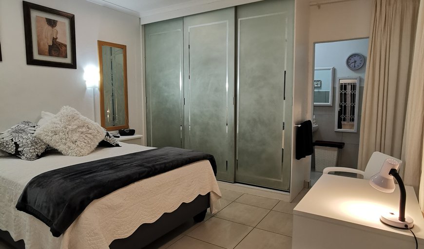 The bedroom is furnished with a queen size bed and a flat screen TV in Durban North, Durban, KwaZulu-Natal, South Africa