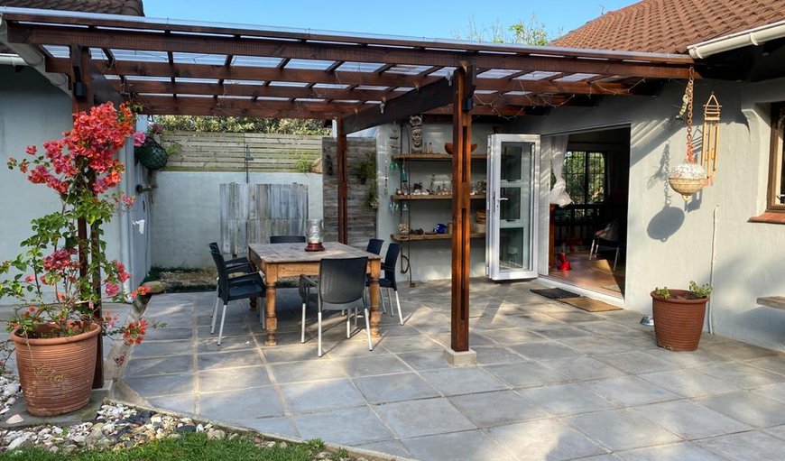 The cottage features a private covered back verandah with a garden firepit