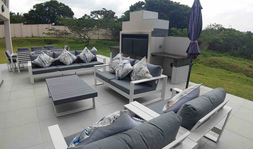 Patio with a braai area, dining area and comfortable seating
