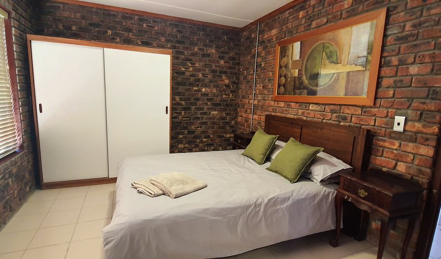 14E Vasco da Gama Flat: The bedroom has a double bed and an en-suite bathroom with a shower, toilet and basin