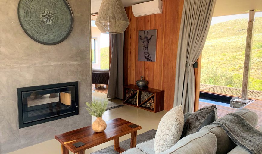 The living area includes a dining table and 2 chairs, a lounge, and leads onto the patio with built-in fireplace and outdoor table and chairs The living area includes a dining table and 2 chairs, a lounge, and leads onto the patio with built-in fireplace and outdoor table and chairs