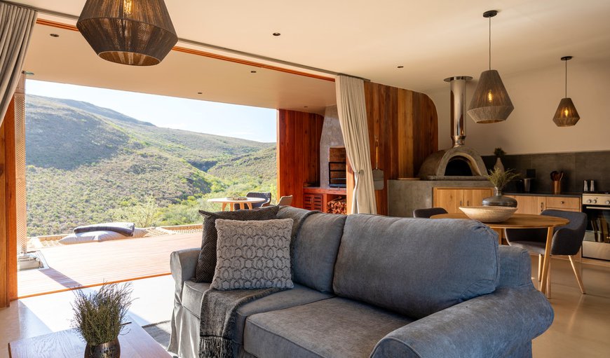The living area has a dining table and 2 chairs, a sofa and a fireplace, and leads onto the patio which offers a built-in braai and outdoor table and chairs The living area has a dining table and 2 chairs, a sofa and a fireplace, and leads onto the patio which offers a built-in braai and outdoor table and chairs