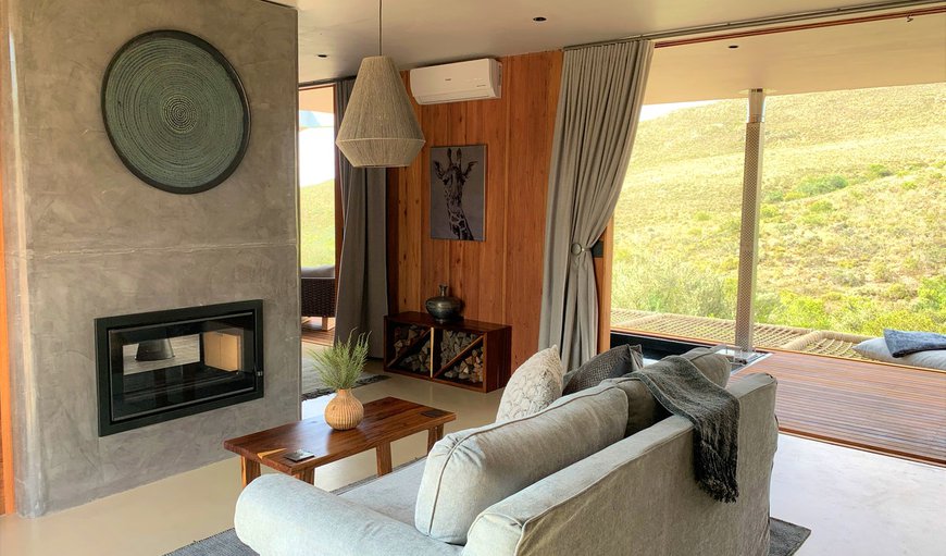 The living area has a dining table and 2 chairs, a sofa and a fireplace, and leads onto the patio which offers a built-in braai and outdoor table and chairs The living area has a dining table and 2 chairs, a sofa and a fireplace, and leads onto the patio which offers a built-in braai and outdoor table and chairs