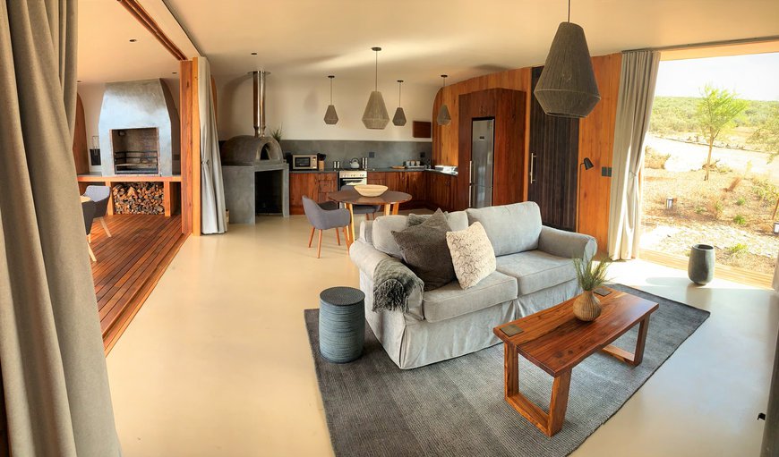 The living area has a dining table and 2 chairs, a sofa and a fireplace, and leads onto the patio which offers a built-in braai and outdoor table and chairs The living area has a dining table and 2 chairs, a sofa and a fireplace, and leads onto the patio which offers a built-in braai and outdoor table and chairs