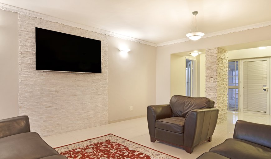 The ground floor features a spacious open plan design lounge with a built-in fireplace and a large wall-mounted flat-screen TV The ground floor features a spacious open plan design lounge with a built-in fireplace and a large wall-mounted flat-screen TV