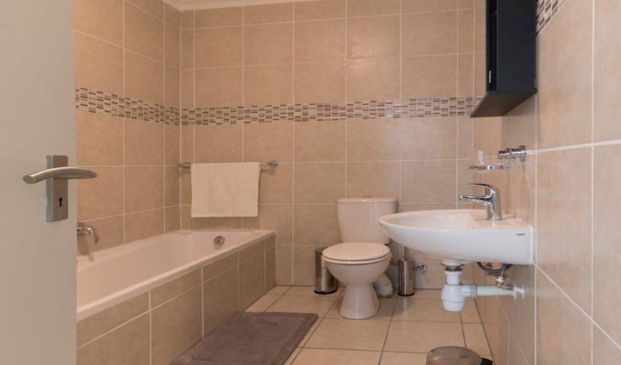 Self-catering 1-Bedroom 14 Azure: Bathroom is fitted with a bath, a basin, and a toilet