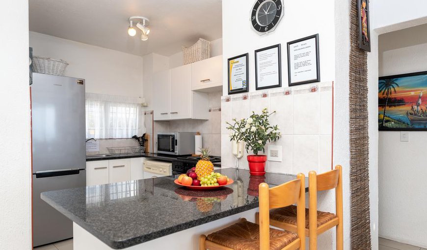 The open plan kitchen is equipped with a fridge/freezer, stove and oven, microwave and a washing machine. The open plan kitchen is equipped with a fridge/freezer, stove and oven, microwave and a washing machine.